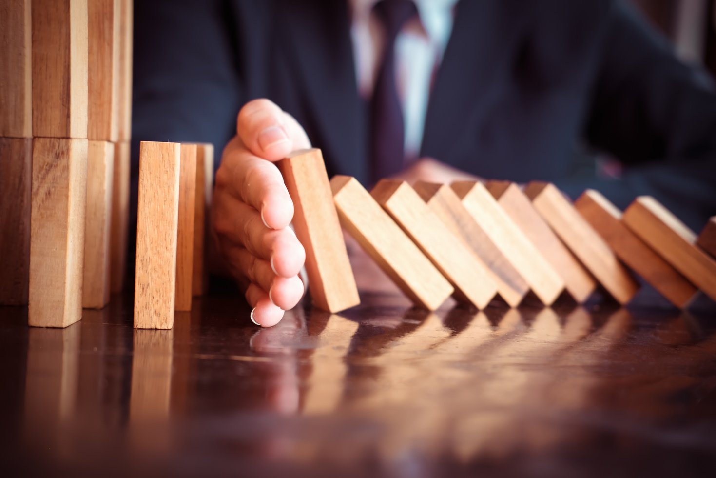 Business Man Placing Wooden Block on a Tower Concept Risk Contro